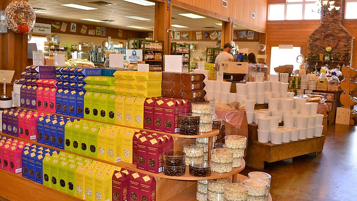 Boxes, tins and tubs of pecans on shelves in store