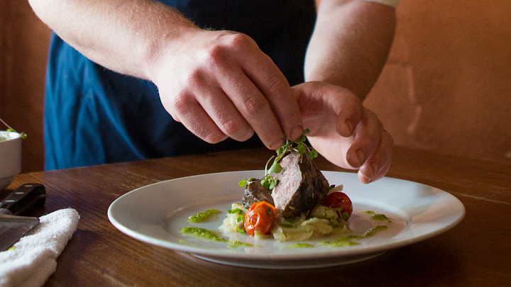 Chef plating a meal at Motor Supply Company