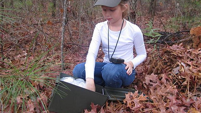 young girl finding geocache 