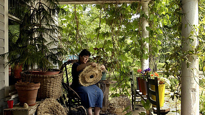 woman on front porch making a basket