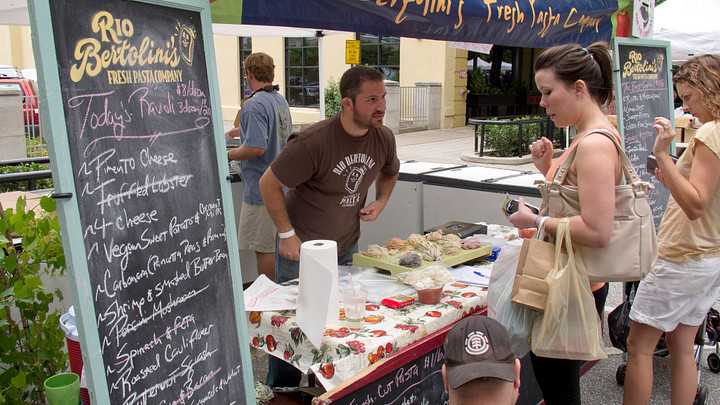 Customers buying baked goods from vendor at TD Saturday Fresh Market in Greenville